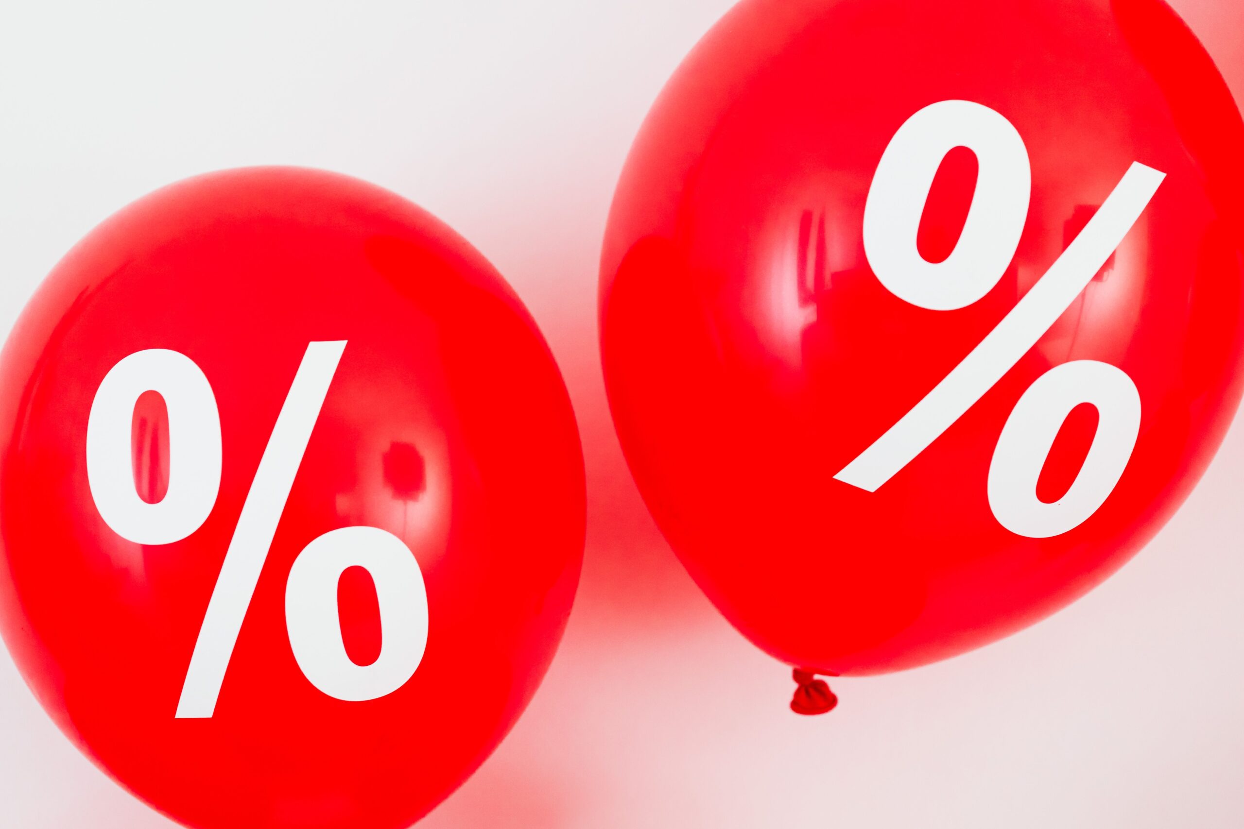 Red balloons featuring percentage symbols, ideal for sales and promotions.