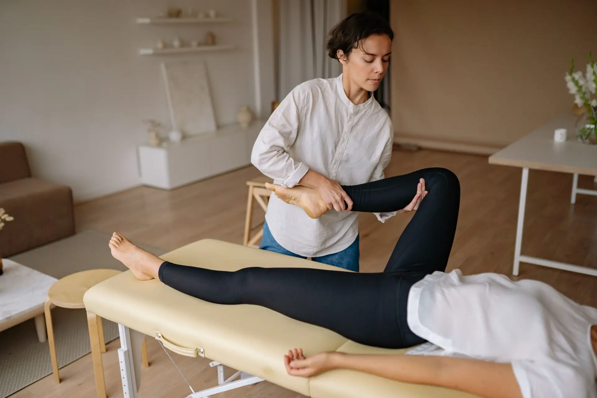 A massage therapist provides a rejuvenating leg treatment in a calming spa environment.